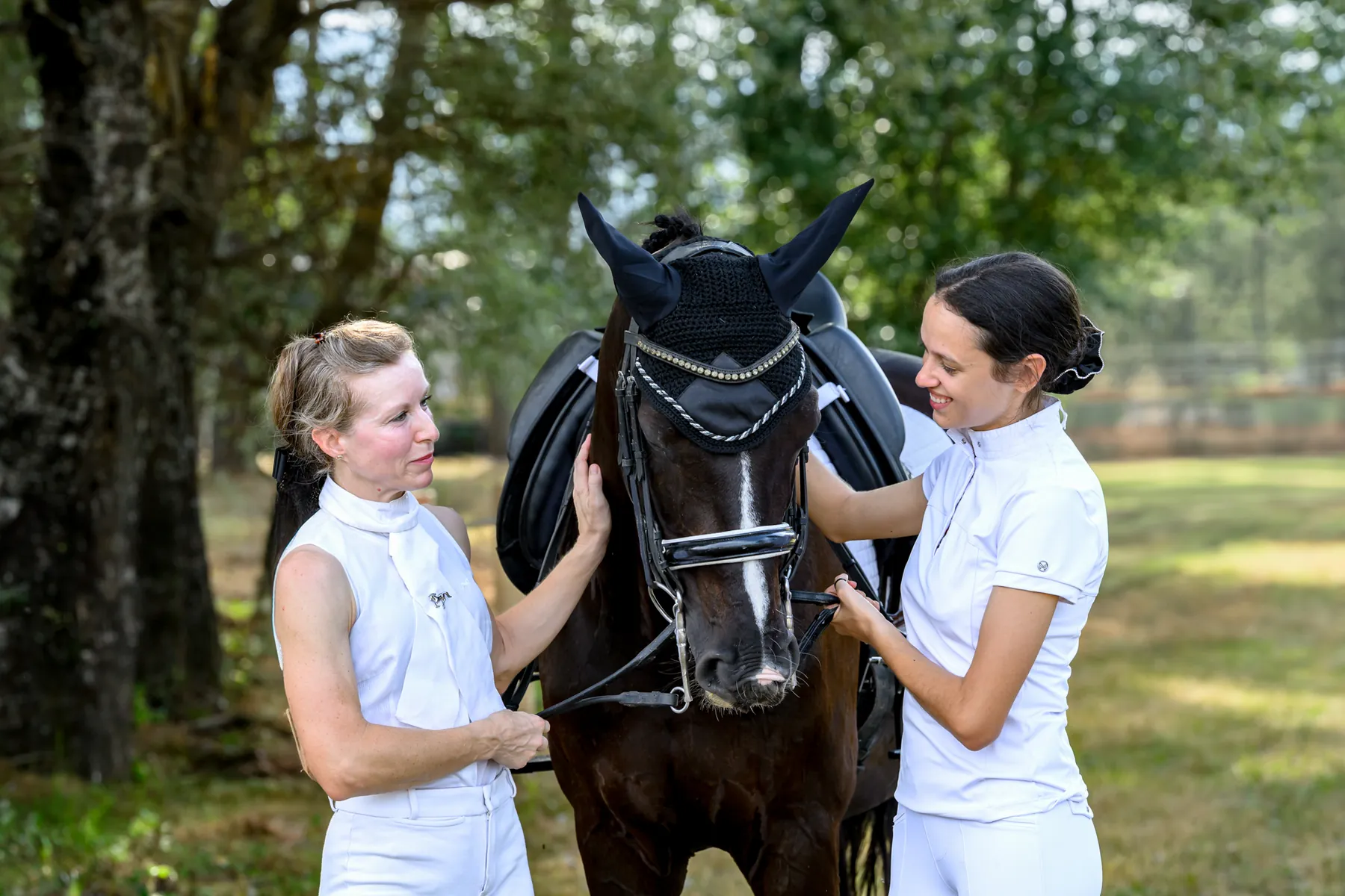 Dos compañeras compartiendo un momento con un caballo al aire libre
